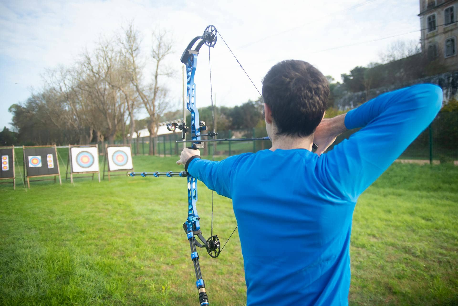 An archer aiming at a target with a bow sight